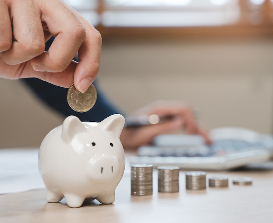 Man putting money in a piggy bank. Saving money for nonprofits concept.